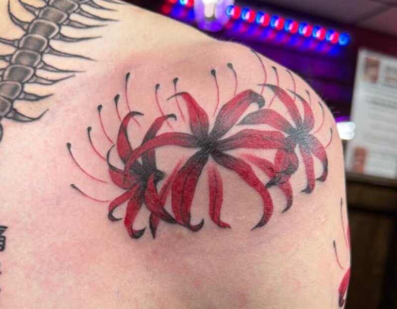 Color spider lily tattoo by Mindcrusher Tattoo, Rogers Park Chicago