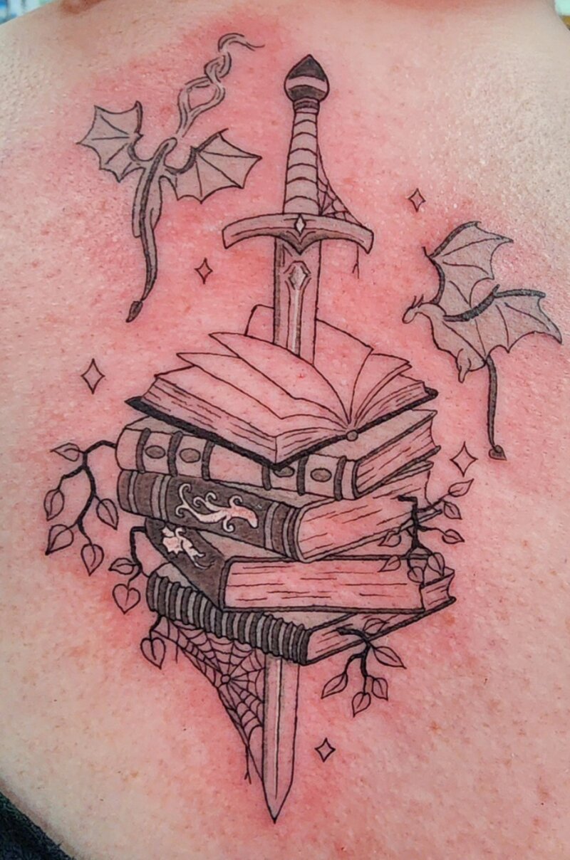 Illustrative sword and books tattoo by Mindcrusher Tattoo, Rogers Park Chicago